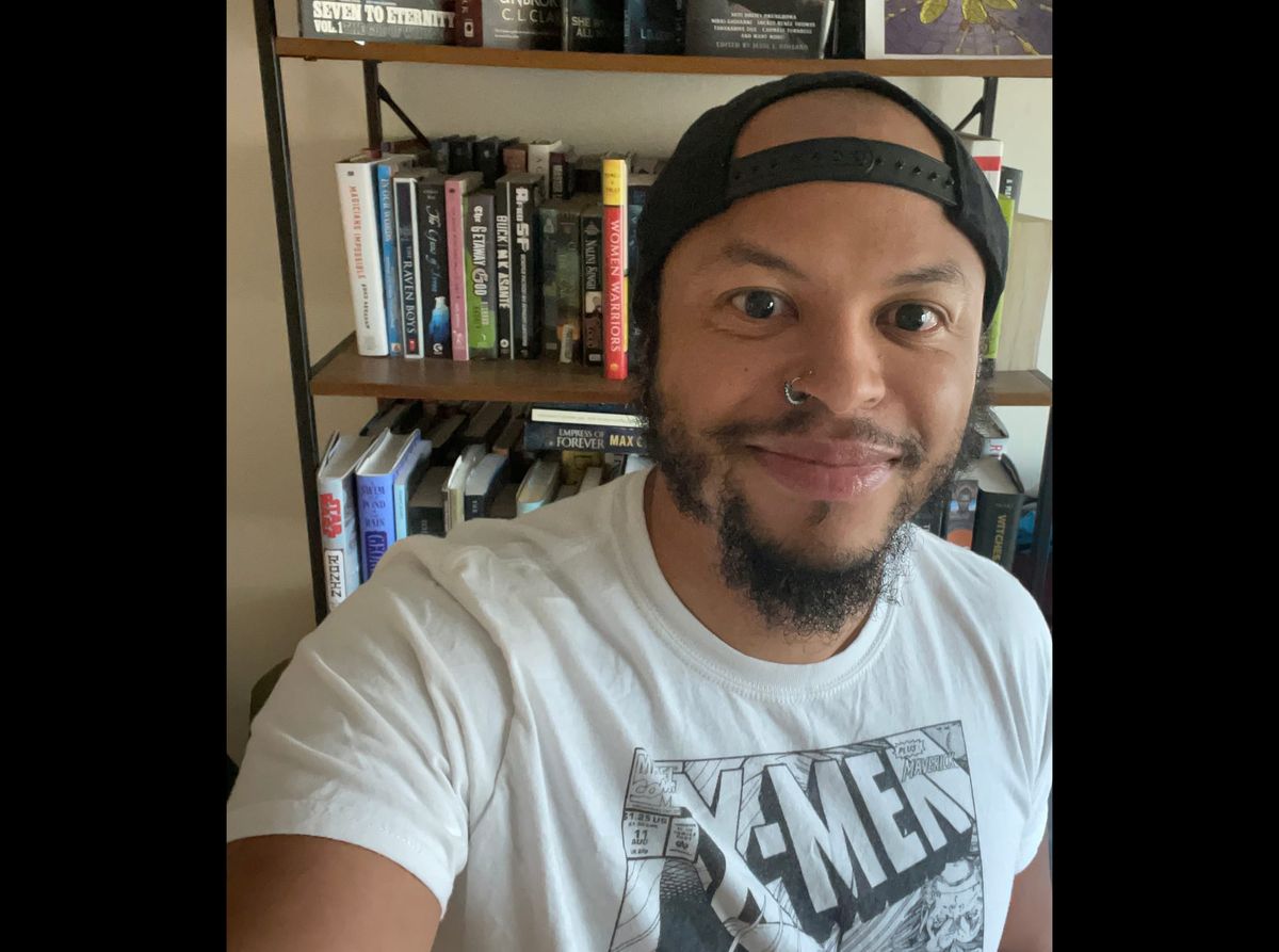 Photograph of Brent wearing an X-Men t-shirt and a backwards baseball cap.