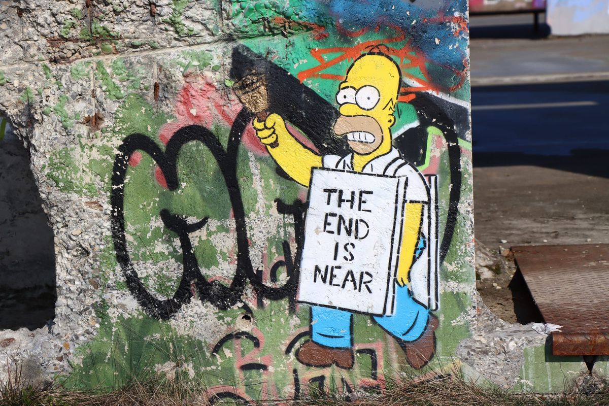 Photograph of graffiti of Homer Simpson ringing a bell and wearing a sandwich board reading "THE END IS NEAR." 