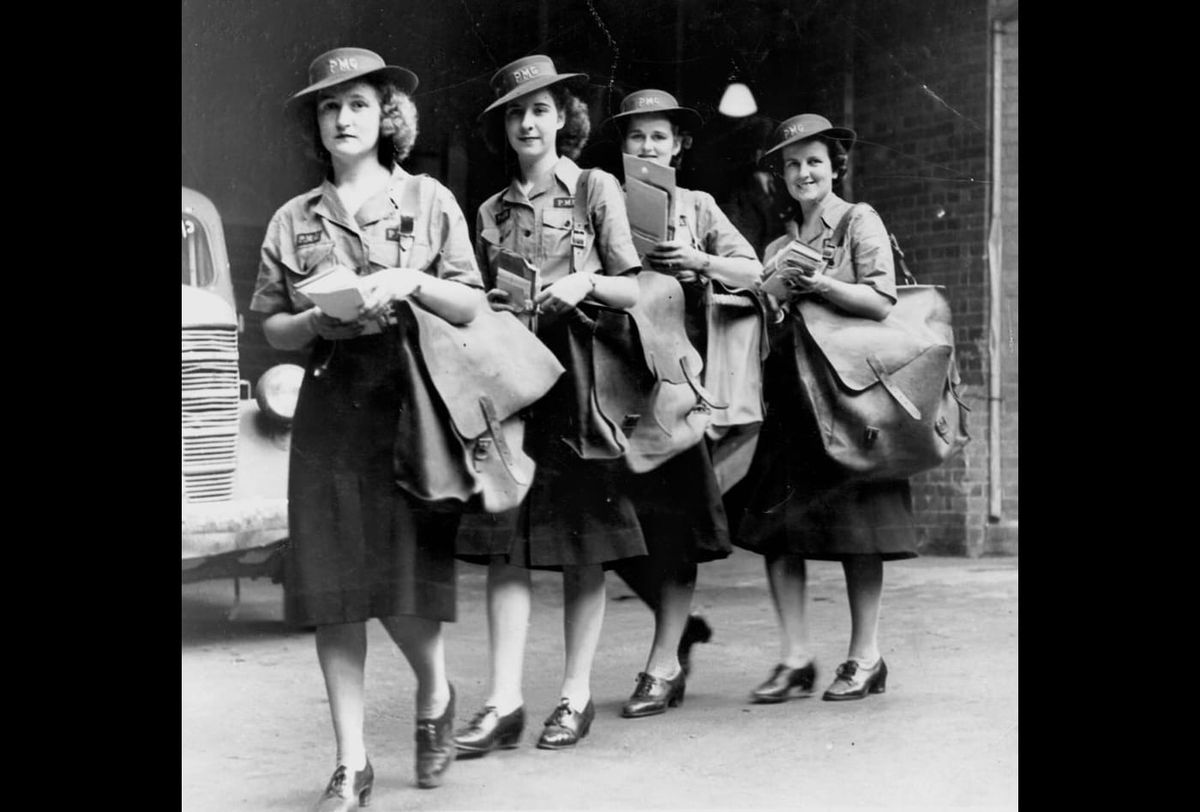 Black and white photo of four female mail carriers. 