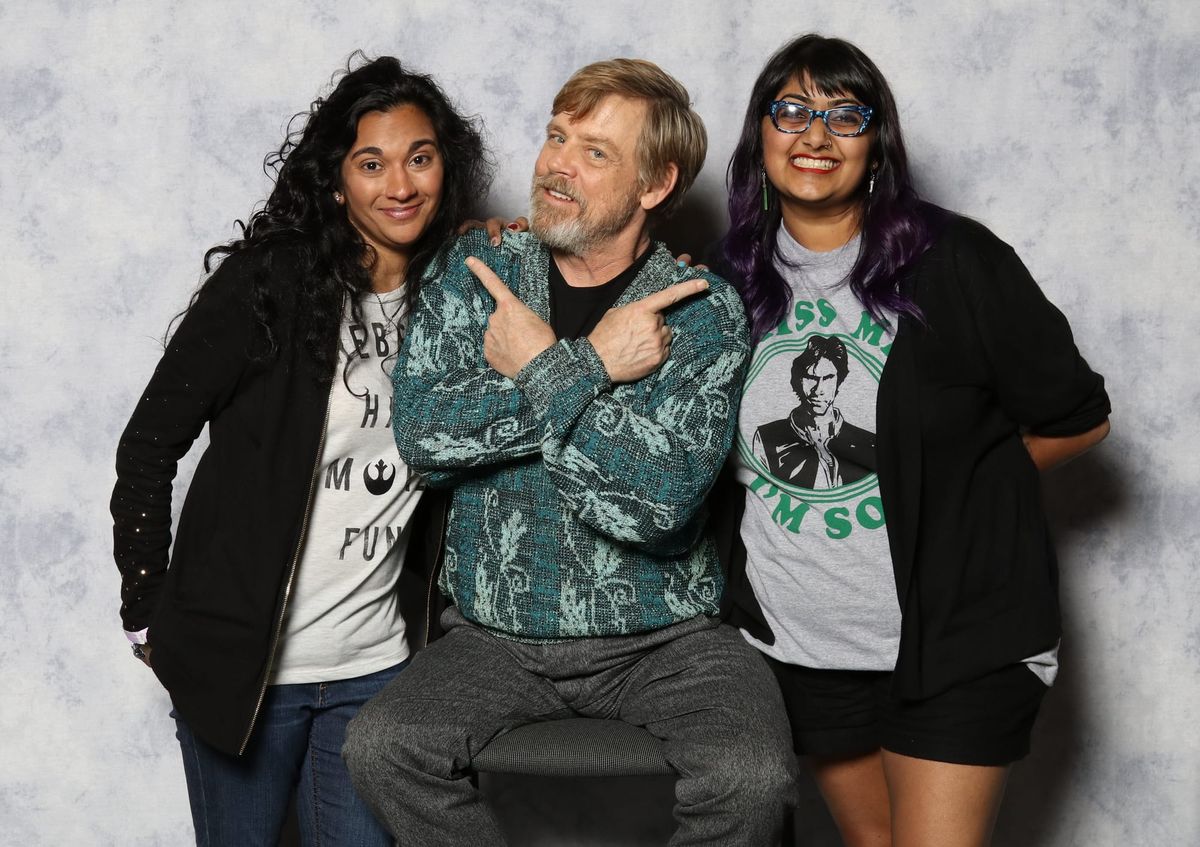 Swapna and Preeti stand on either side of Mark Hamill at a convention photo opportunity. 
