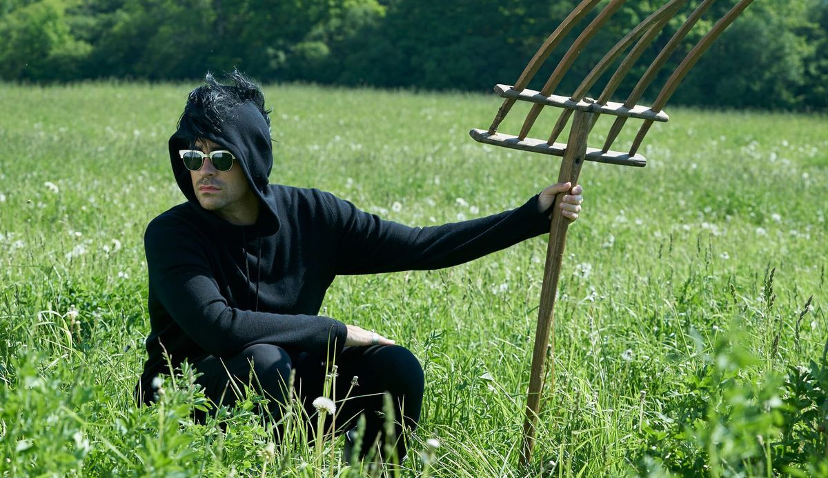 David from Schitt's Creek in a field with a pitchfork. 
