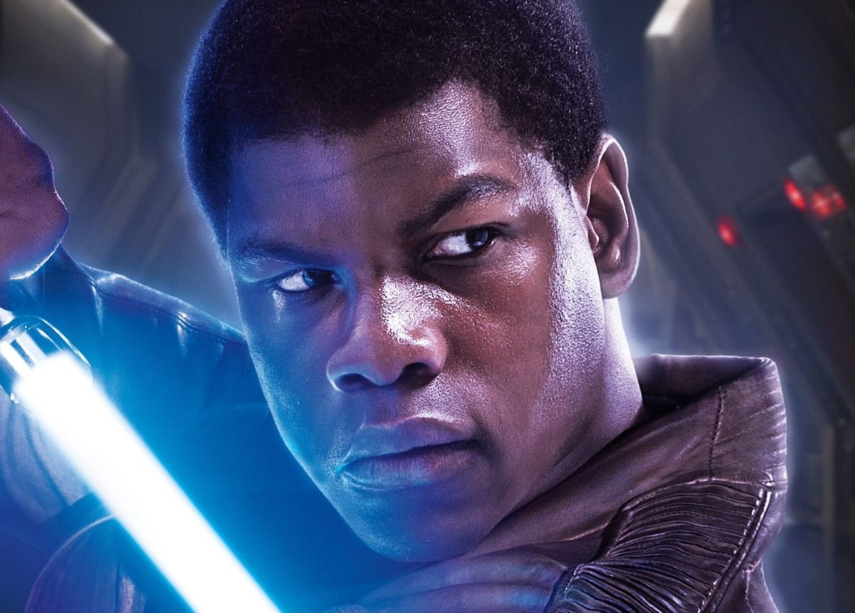 Finn in a promo image for The Force Awakens holding a lightsaber. 