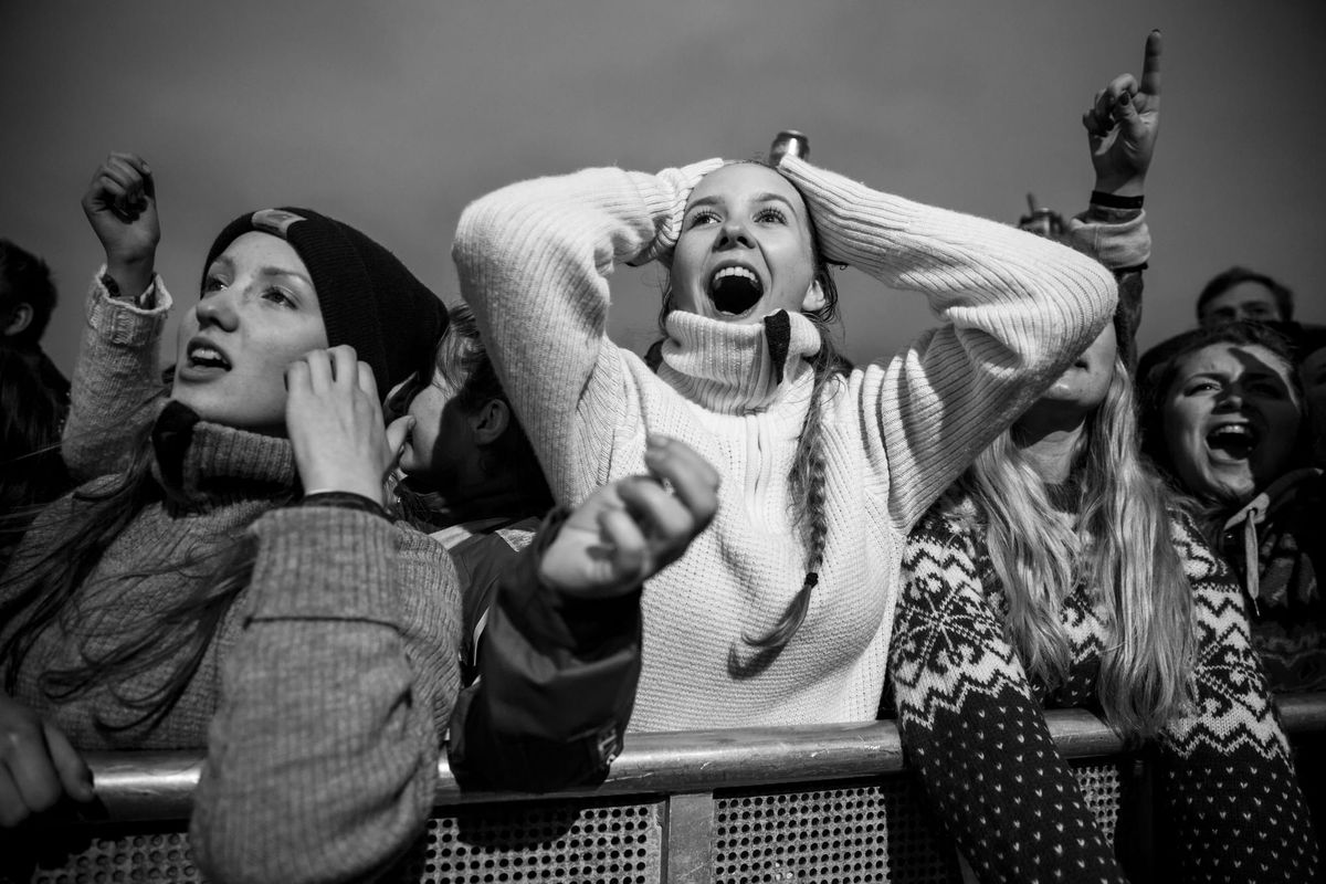 Female fans scream at the approach of an celebrity out-of-frame. 