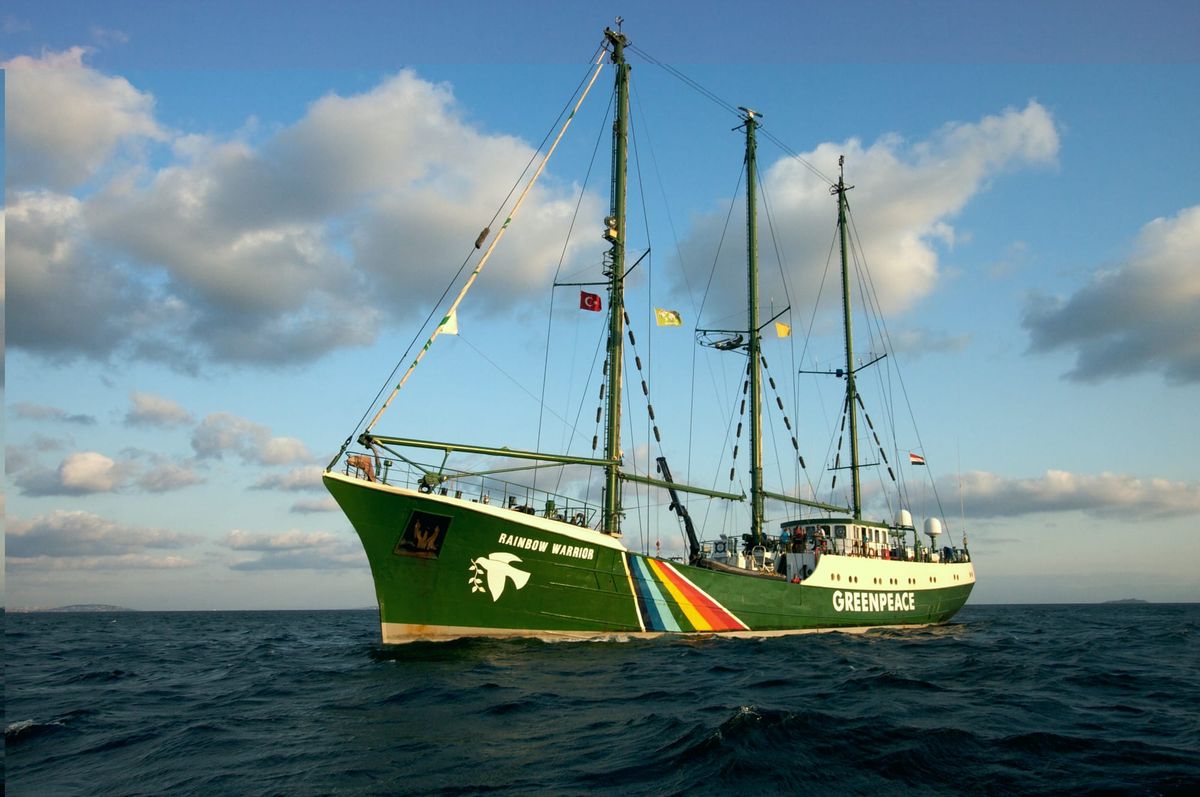 Image of the Greenpeace ship the Rainbow Warrior at sea (a green and white three-masted ship with a peace dove and big rainbow on the side)