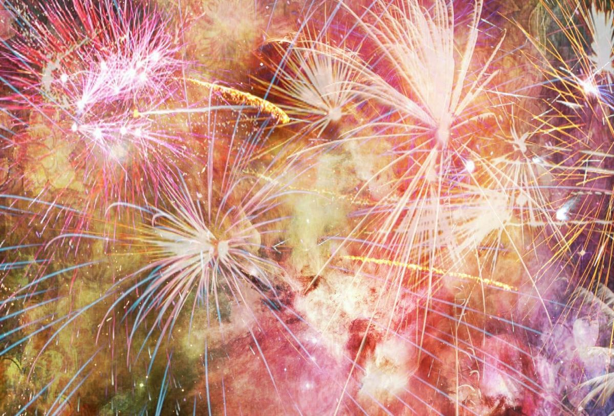 Image of a huge burst of fireworks in shades of red and gold.