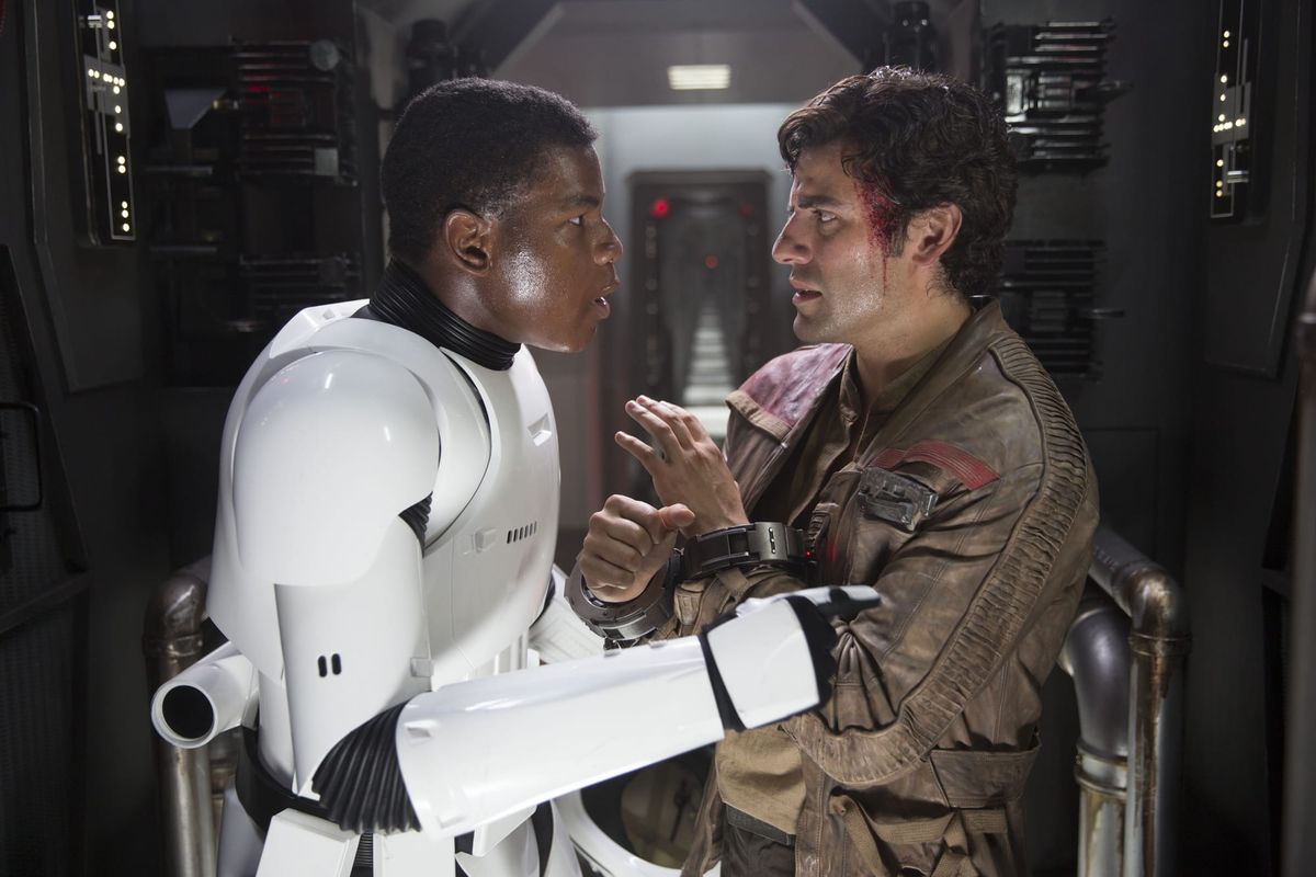 Finn, in his stormtrooper uniform, speaks with Poe. 