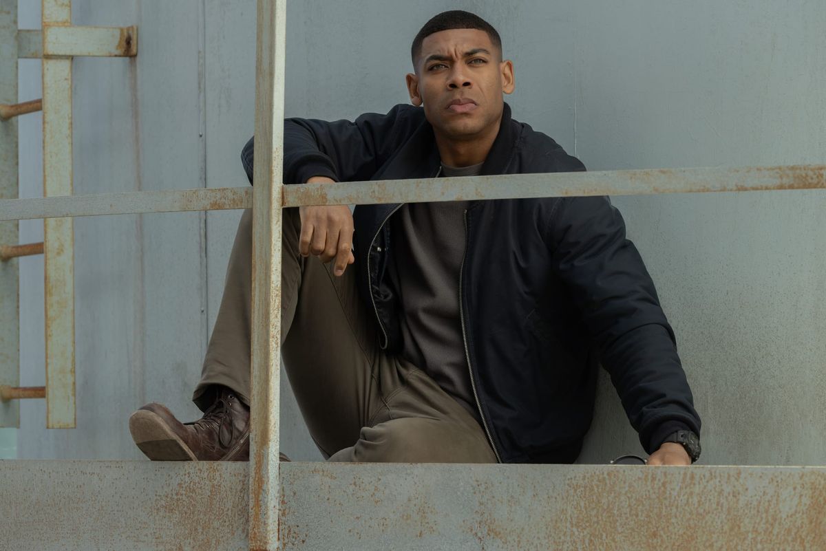 Production still featuring John sitting on the platform of the water tower.
