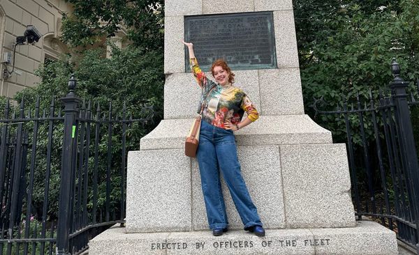 Photograph of Allegra in front of a statue of Robert Falcon Scott.