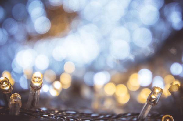 A photograph of white holiday lights, a bokeh effect transforming them into abstract twinkles.
