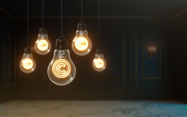 Image of five lightbulbs hanging upside-down with copyright symbols illuminated in them.