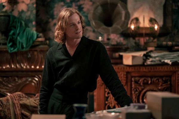 Lestat from AMC's Interview with the Vampire dressed in all black and leaning against a table.