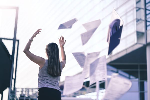 A woman tosses papers into the air.