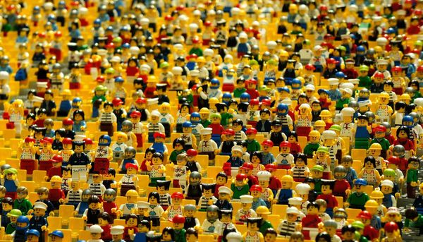 Image of many Legos in a yellow Lego stadium