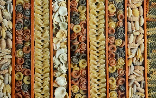 A photograph featuring rows of sorted pasta shapes