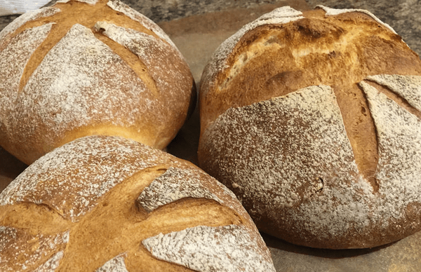  Photograph of three loaves of crusty bread. 