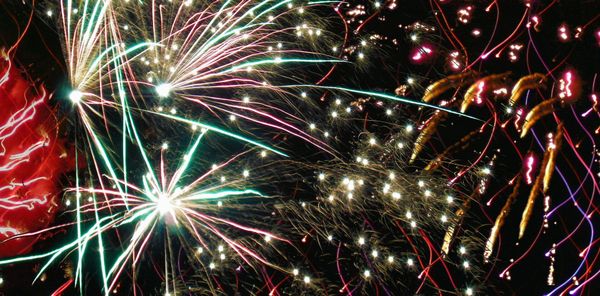 Image of fireworks in shades of red, white, yellow, and green.