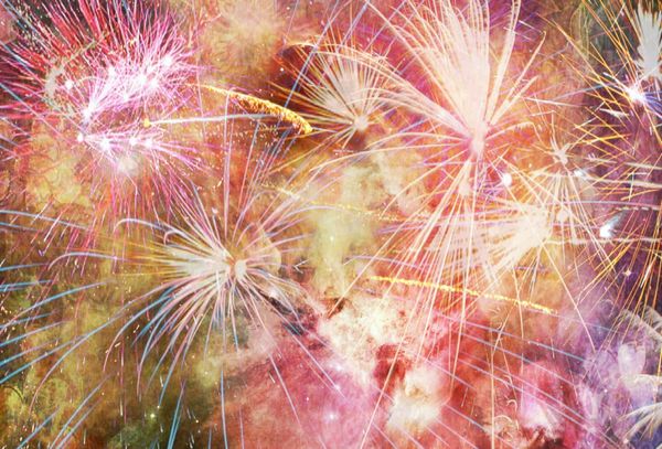 Image of a huge burst of fireworks in shades of red and gold.