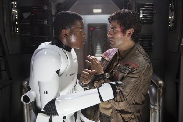 Finn, in his stormtrooper uniform, speaks with Poe. 
