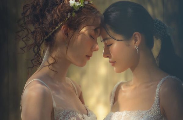 Thai GL stars Orm Kornnaphat and Lingling Sirilak Kwong, aka LingOrm strikpose with foreheads touching and eyes closed in a gauzy promotional poster for the upcoming series In Love Forever.
