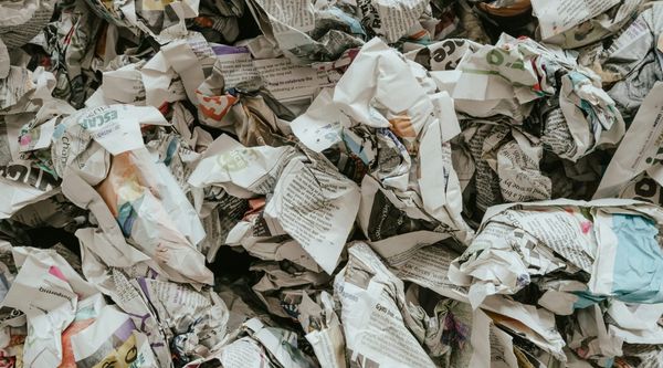 Photograph of a pile of crumpled-up newspapers.