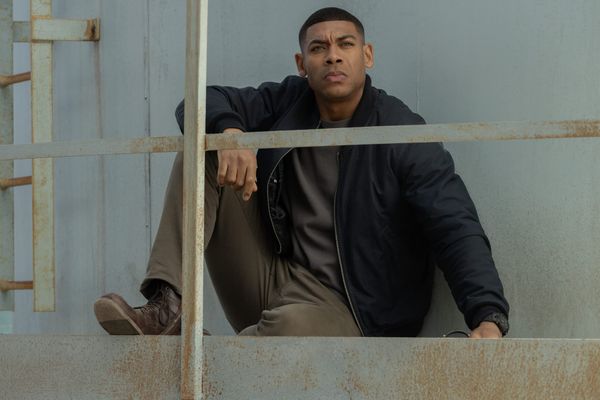 Production still featuring John sitting on the platform of the water tower.
