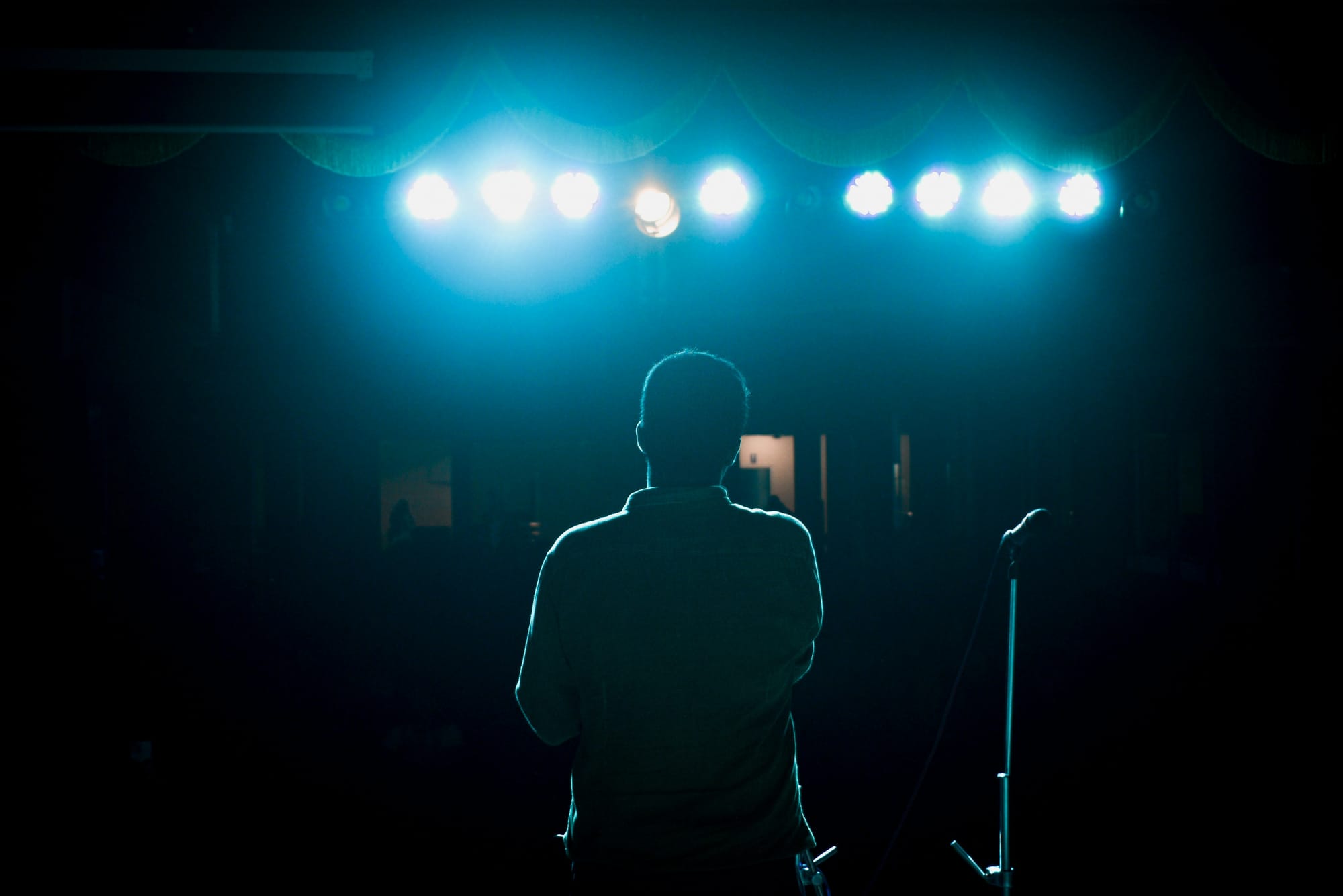 A solo singer on stage overcoming his fear and facing the spotlights