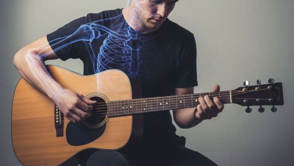 Musician playing guitar with good posture to prevent guitar playing pain 