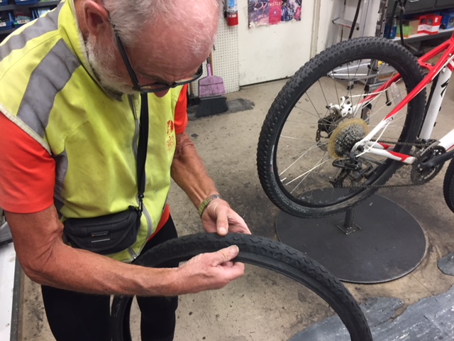  Francois inspects the tire that was damaged on his bicycle.  His tire and wheel were fixed at Kevin’s Bikes in Merced and he was on his way after a couple of hours.  Photo: Steve Newvine. 