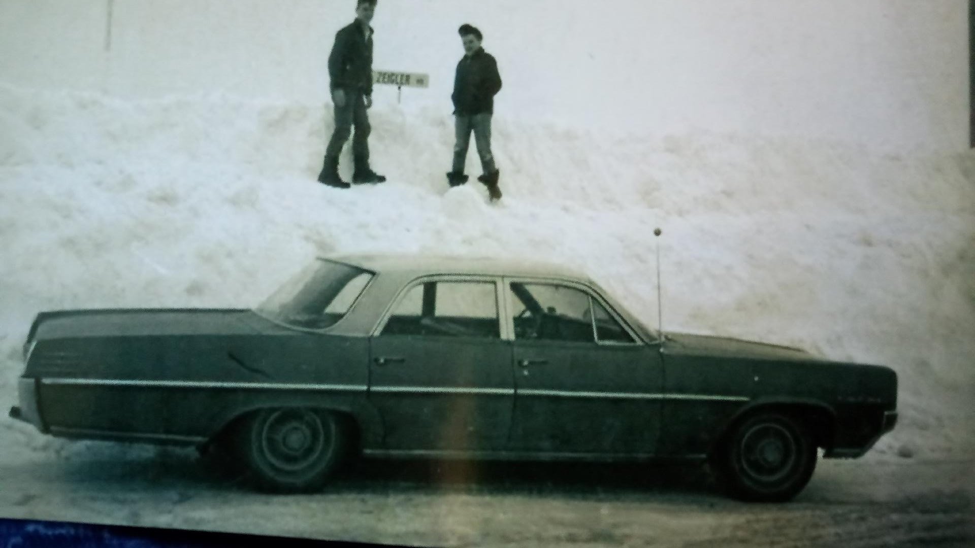  That’s my older brother and me on top of a snowbank during a particularly heavy snow-filled winter in upstate New York.  The family car, a Pontiac Star Chief, is parked below us.  Photo:  Newvine Personal Collection 