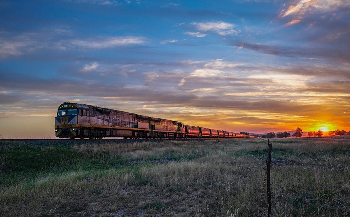 A grain freight train crossing Central Western NSW at sunset