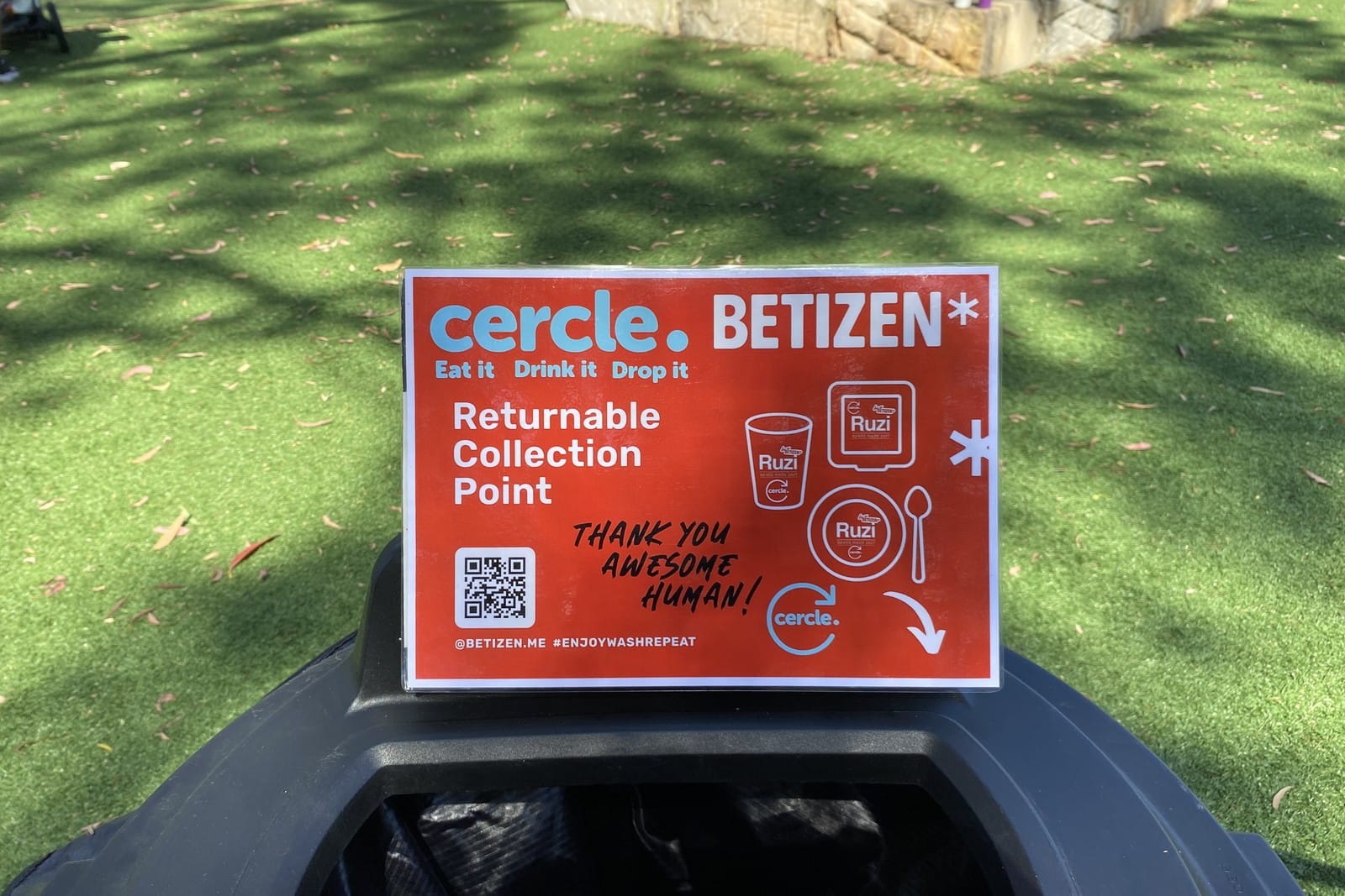 A red Cercle and Betizen sign reading Returnable Collection Point on top of a black bin