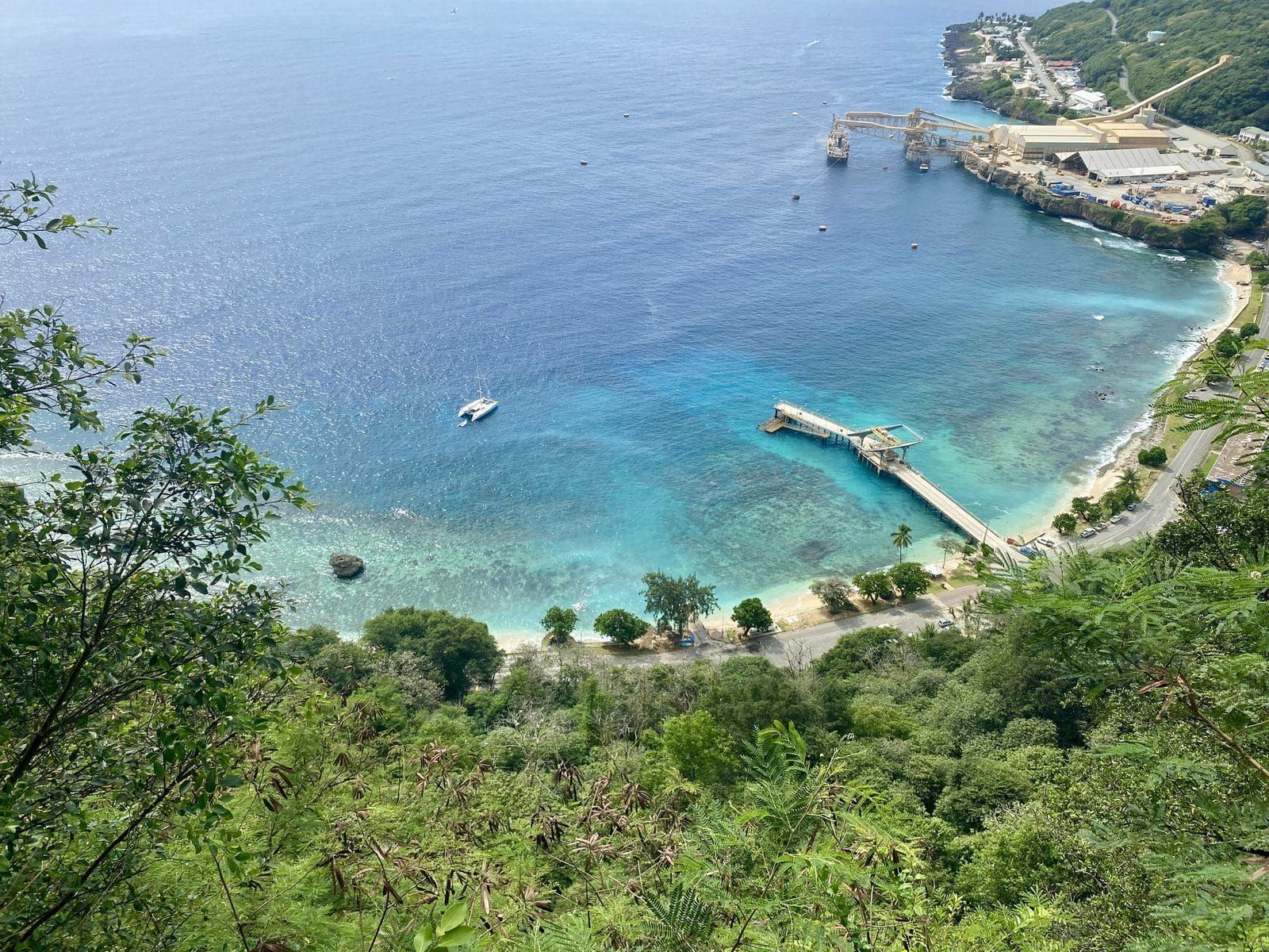 Flying Fish Cove from the clifftop, turquoise water and the wharf below the jungle, an Earth to Sea News original