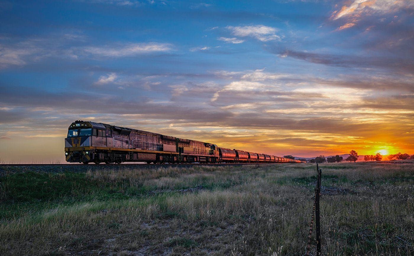 A loaded grain train at sunset in wheat country, photographed by Oliver Strewe