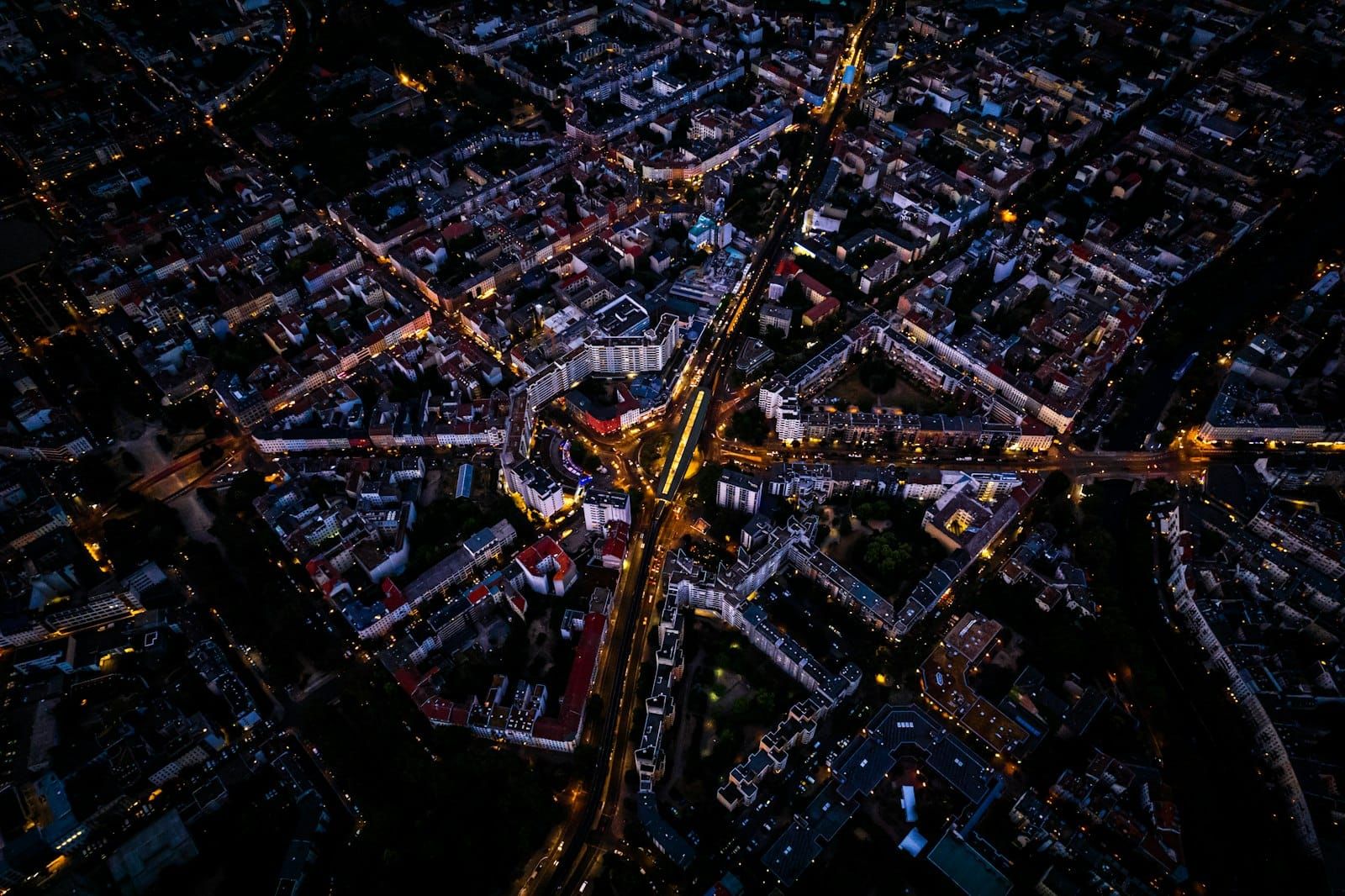 A city seen from above at night, its streets drawn in lines of orange light.