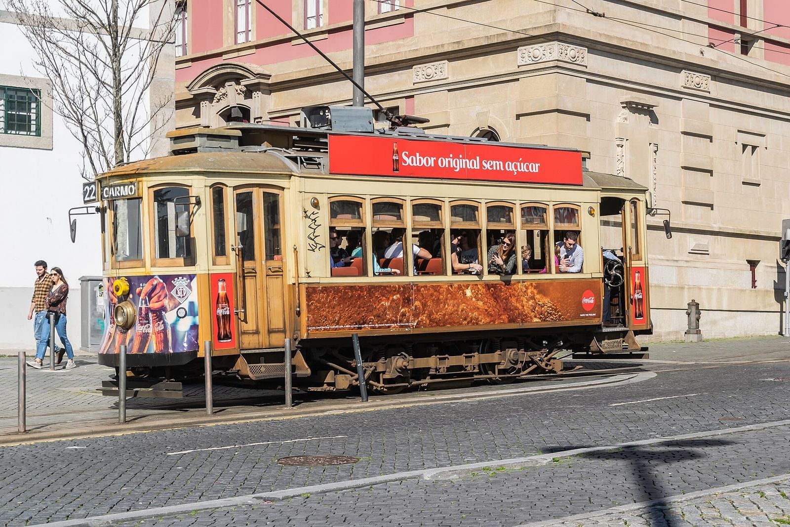 A historic yellow and cream tram on Rua de Augusto Rosa in Porto, Portugal.