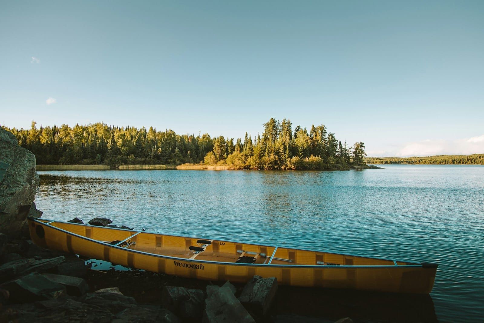 A yellow canoe on the shore of a still lake in Minnesota
