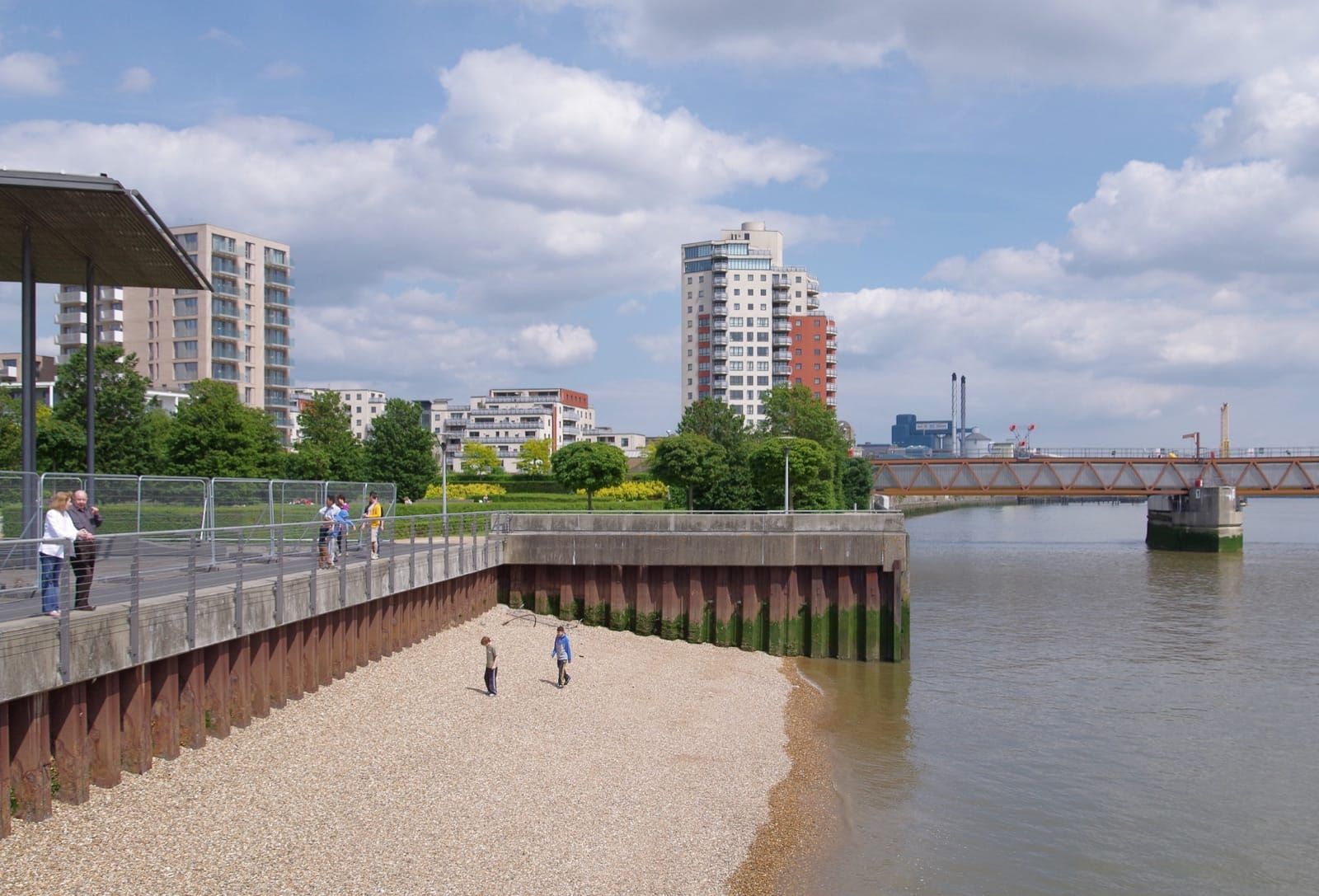 Two children on the small beach beside Thames Barrier Park, London