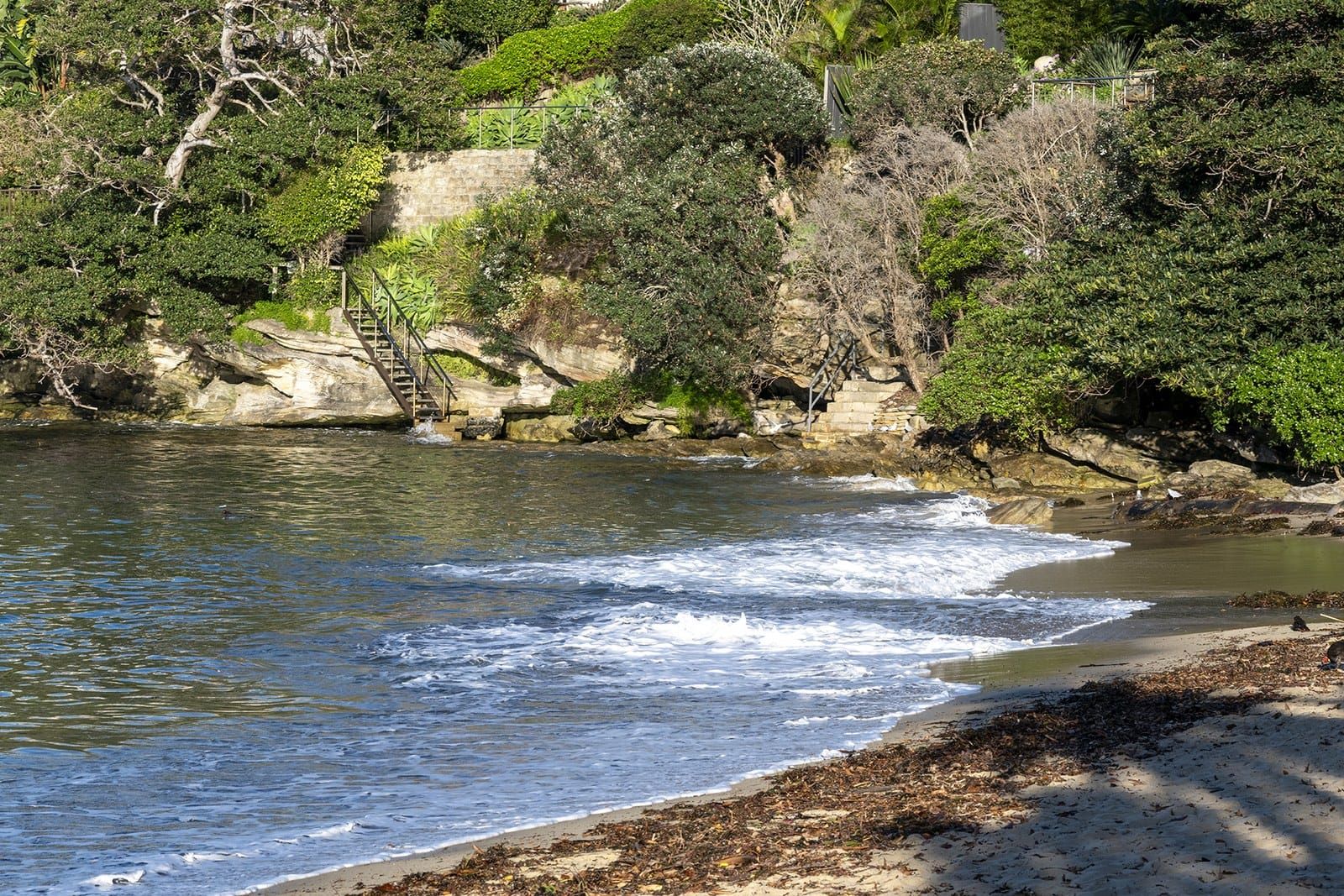 A sandstone staircase through bush down to a small harbour cove