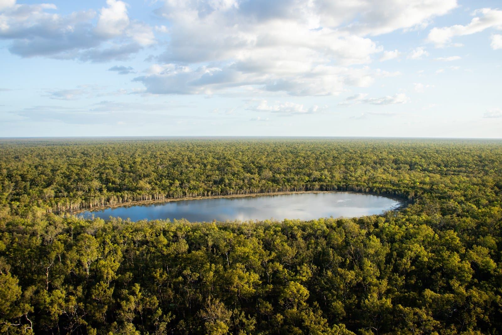A lagoon ringed by green woodland seen from the air, Kendall River Station