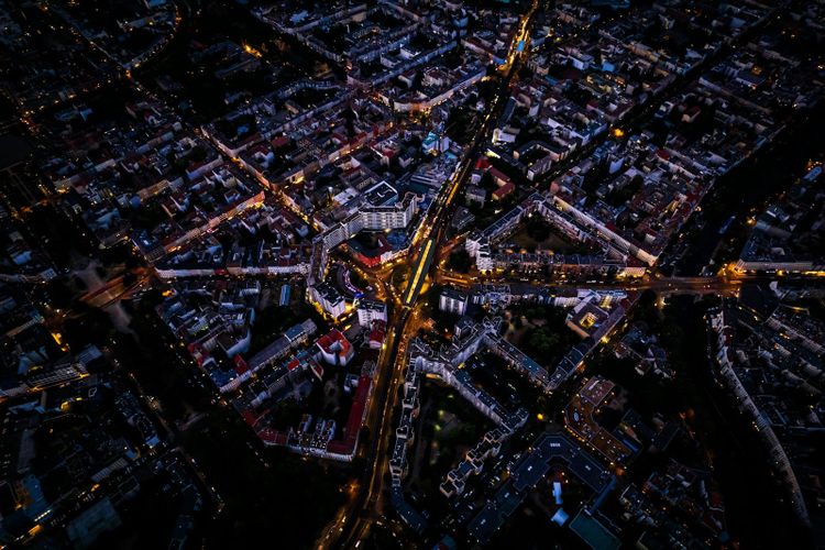A city seen from above at night, its streets drawn in lines of orange light.