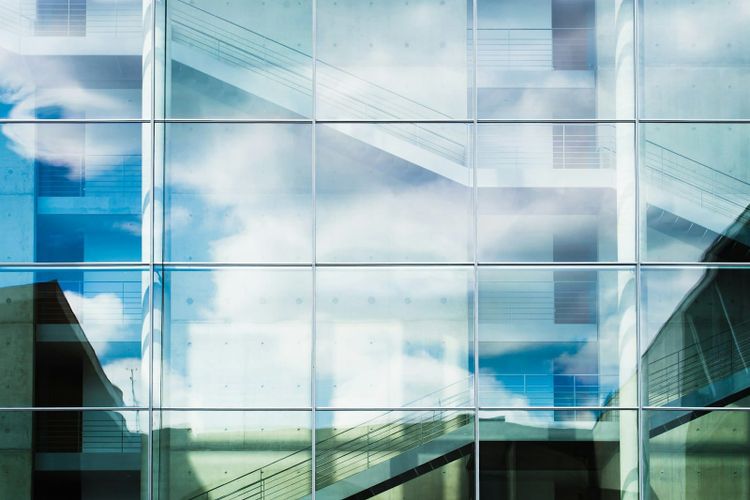 A glass building facade reflecting the sky