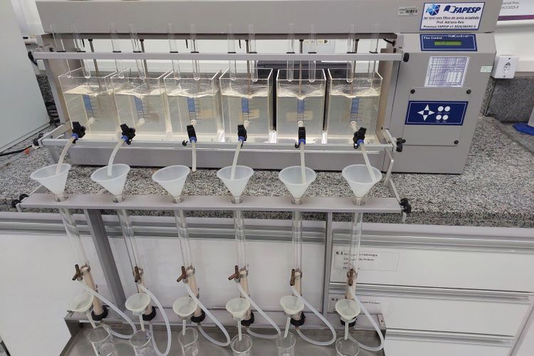 A laboratory jar test rig with six beakers of water, paddles and funnels feeding filters below