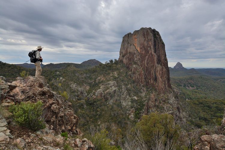 A walker on the Grand High Tops looking across to Belougery Spire and the Breadknife, Warrumbungle National Park