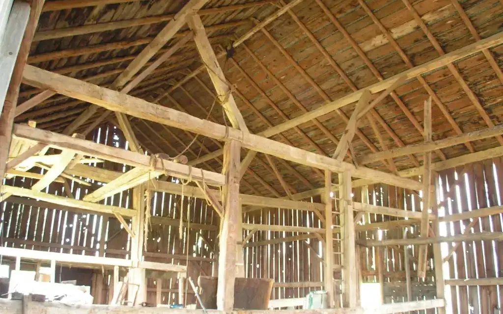 The interior of an old barn, lit from outside