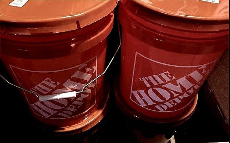 At least four home depot buckets, sealed, stacked up and dimly lit.