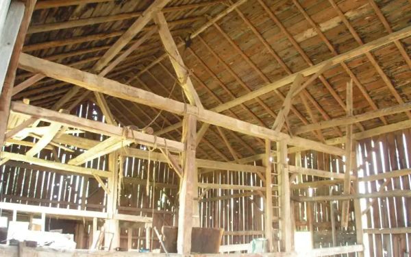 The interior of an old barn, lit from outside