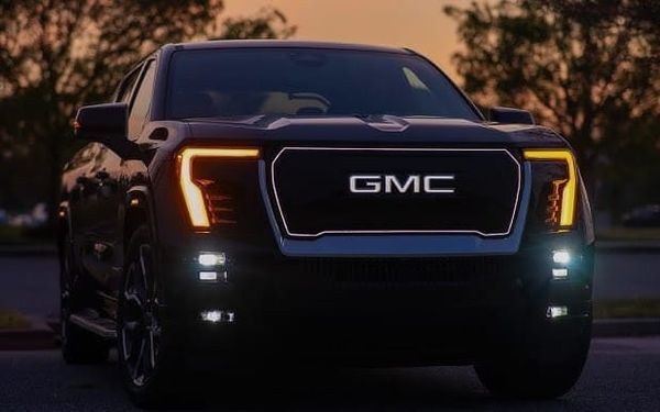 A GMC Sierra Denali, from the front, at dusk.