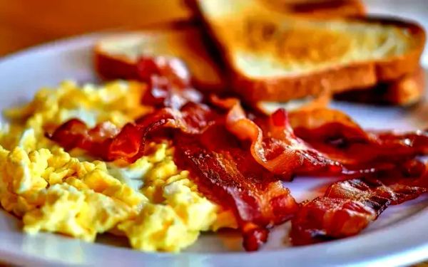 A plate of bacon, eggs, and toast