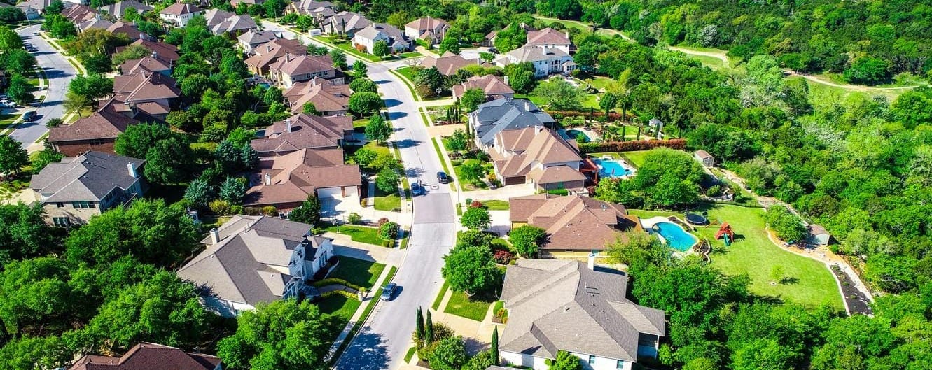 Cedar Park Suburb of Austin. Tree-lined Street with Beautiful Suburban Homes and Pools in the Backyard. 
