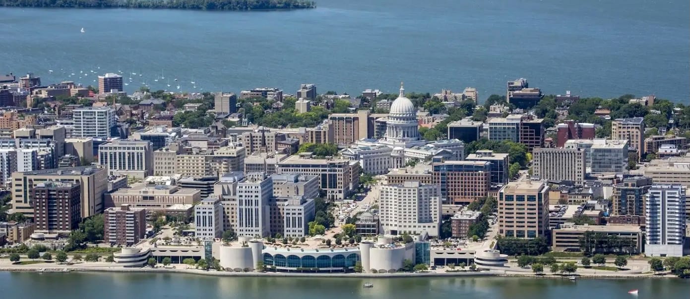 Aerial View of Madison, Wisconsin. Includes Capitol Building in center of image. Lake Monona is in the foreground and Lake Mendota is in the background. 